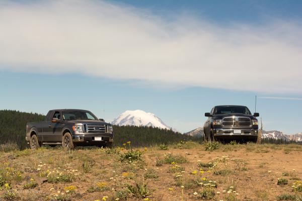 Mt. Rainier in the distance, framed by two pickup trucks in the foreground.